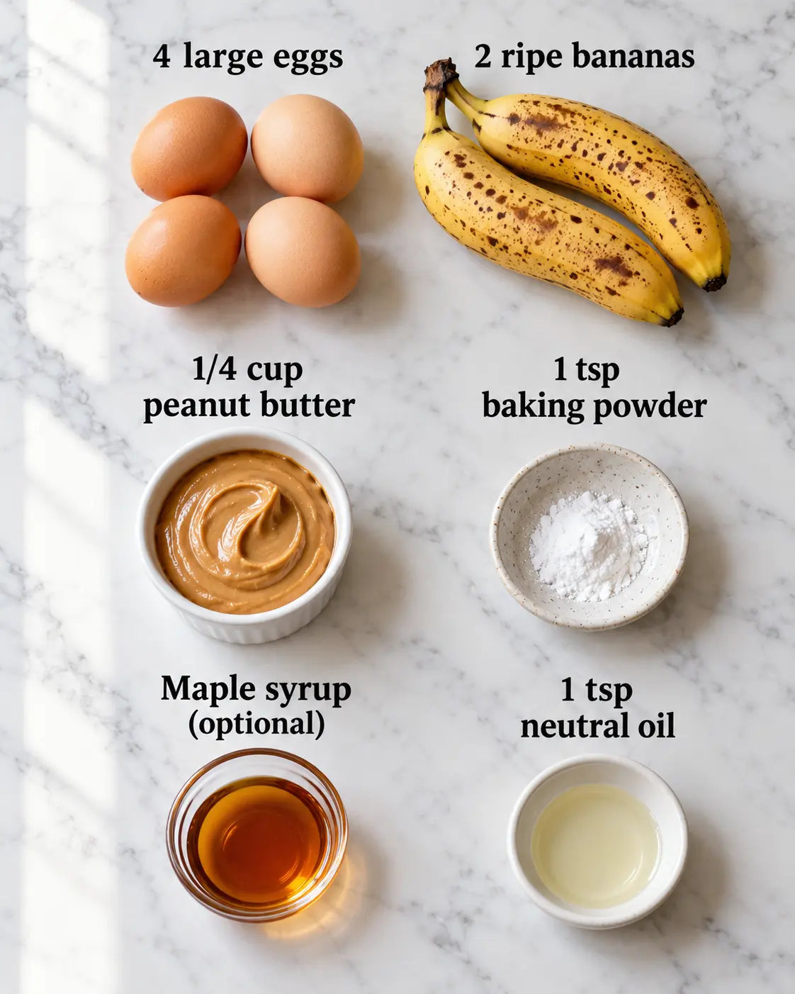 Four eggs, two ripe bananas, peanut butter, baking powder, optional maple syrup and a little neutral oil arranged with readable labels.